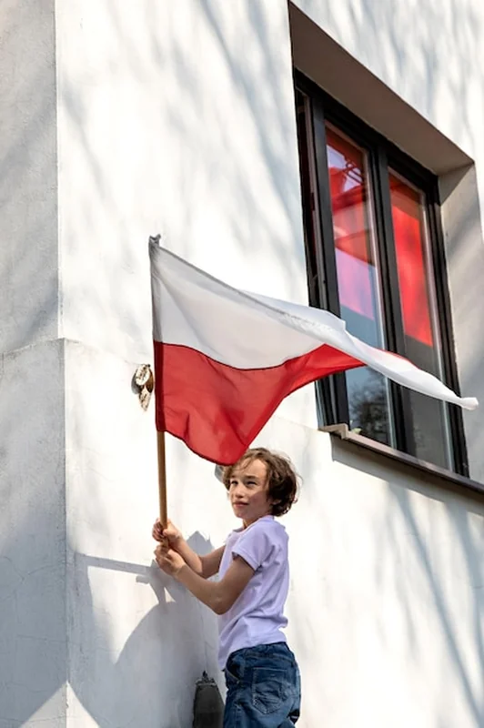 Chłopiec trzymający flagę Polski w dłoniach
