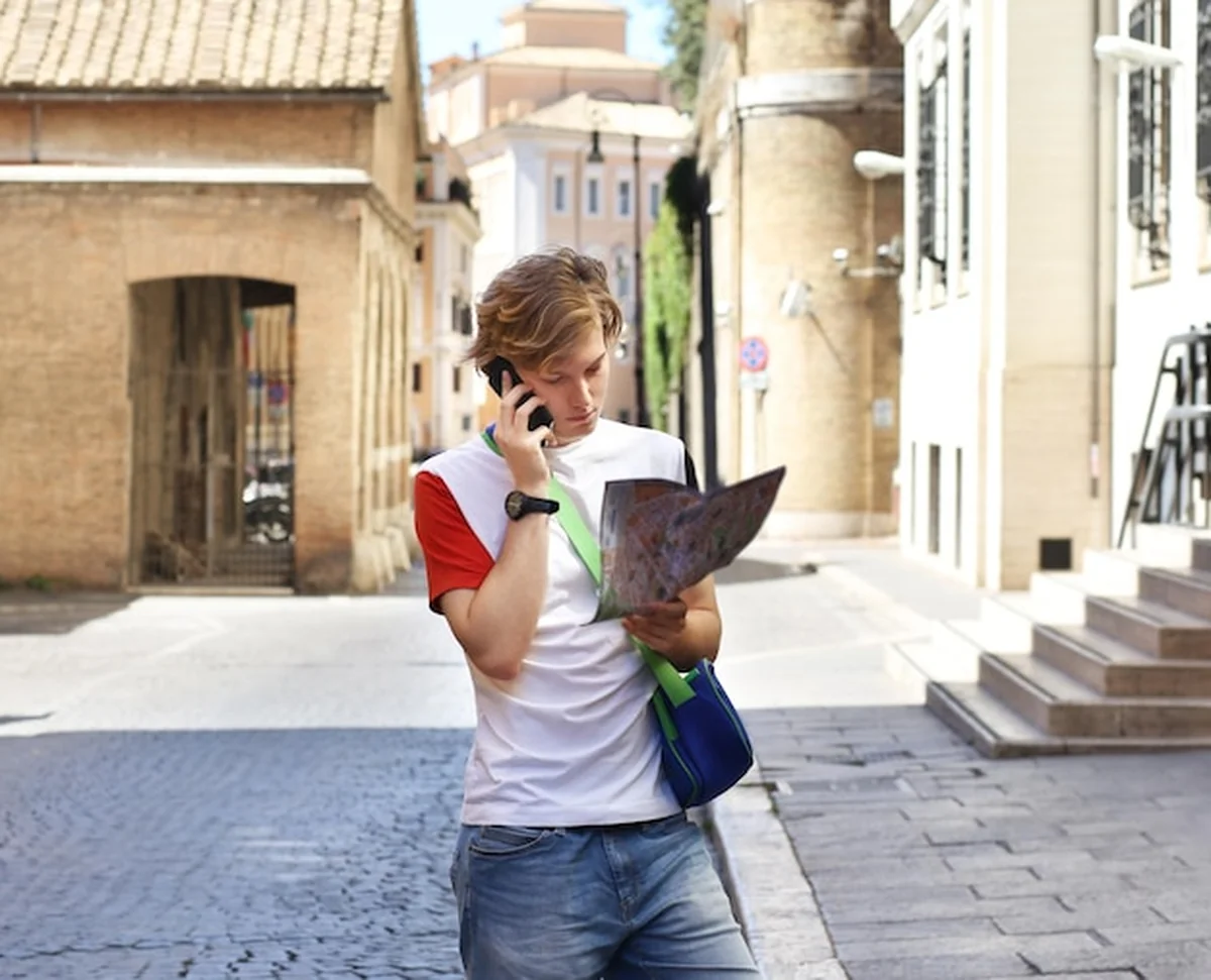 Młody człowiek patrzący na mapę w mieście